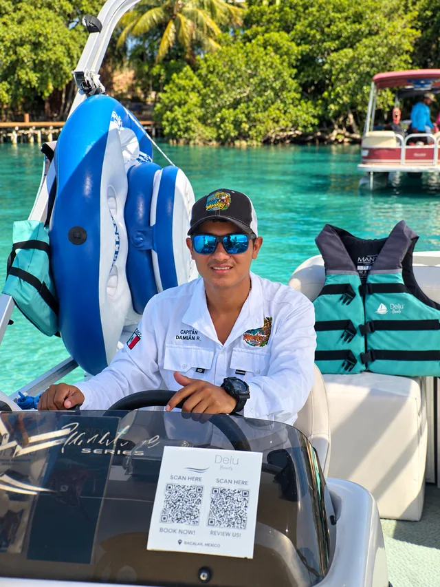Team member at the helm of a pontoon.